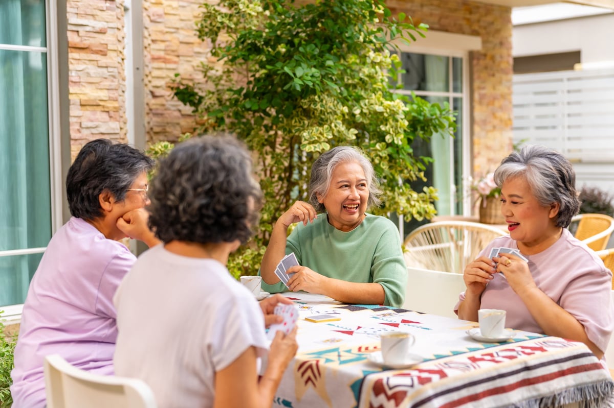 Grupo de señoras mayores jugando cartas y divirtiéndose juntas