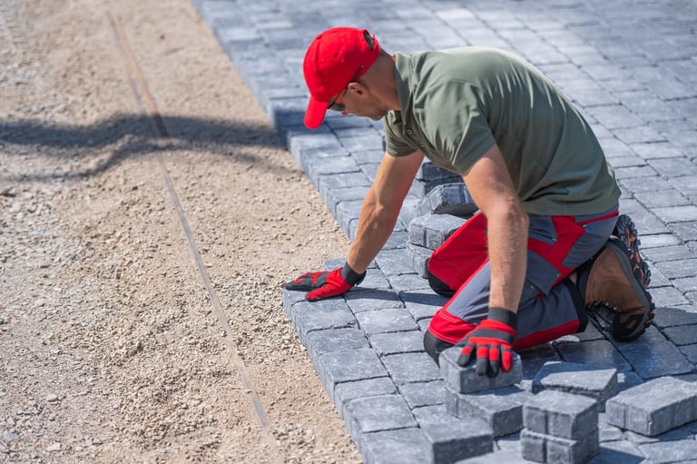 Skilled professional laying pavers with precision