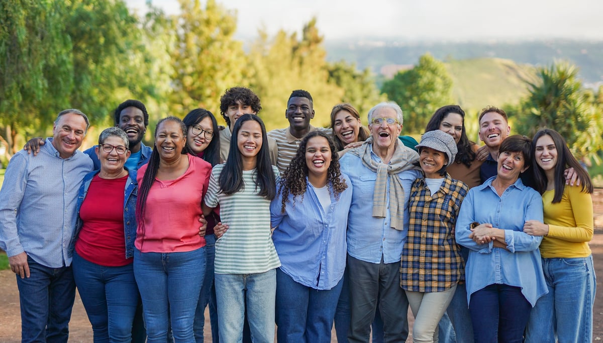 Diverse multiracial crowd of Black and Hispanic people hugging and smiling together in community