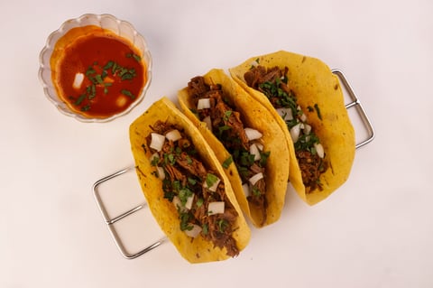 Corn tortilla birria taco with sauce