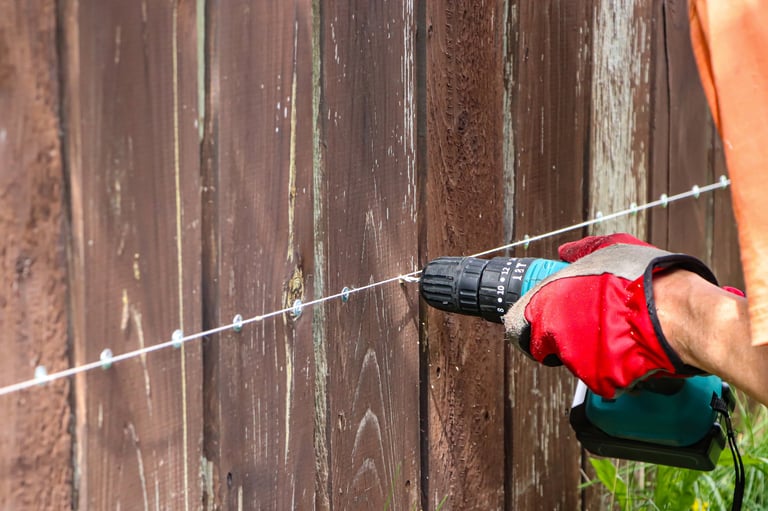 Craftsman repairing a wooden fence with precision