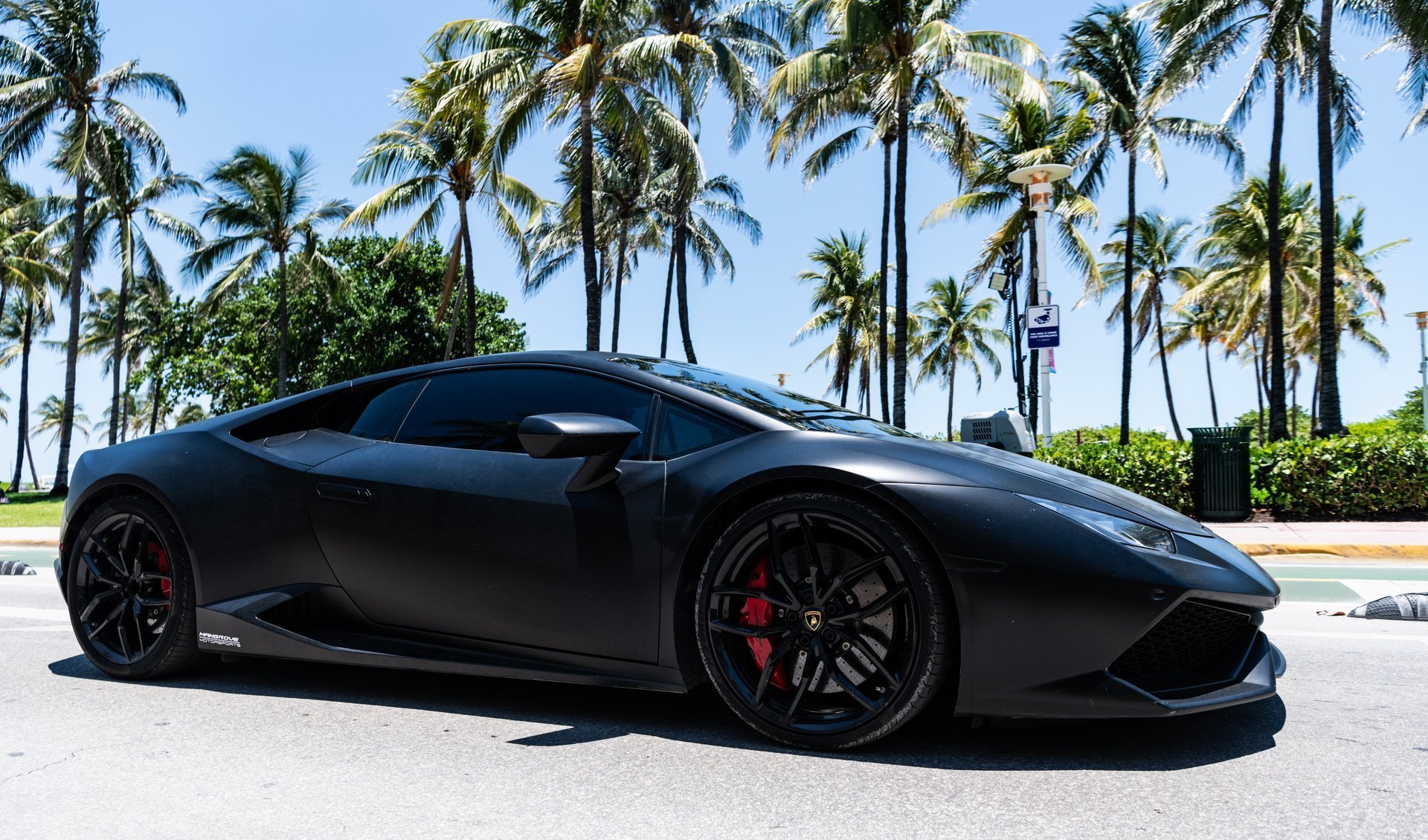 Matte black Lamborghini Huracan parked at the beach at sunset