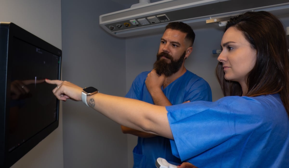 Dos médicos especialistas realizando ecografía intervencionista en entorno hospitalario — nefrología clínica
