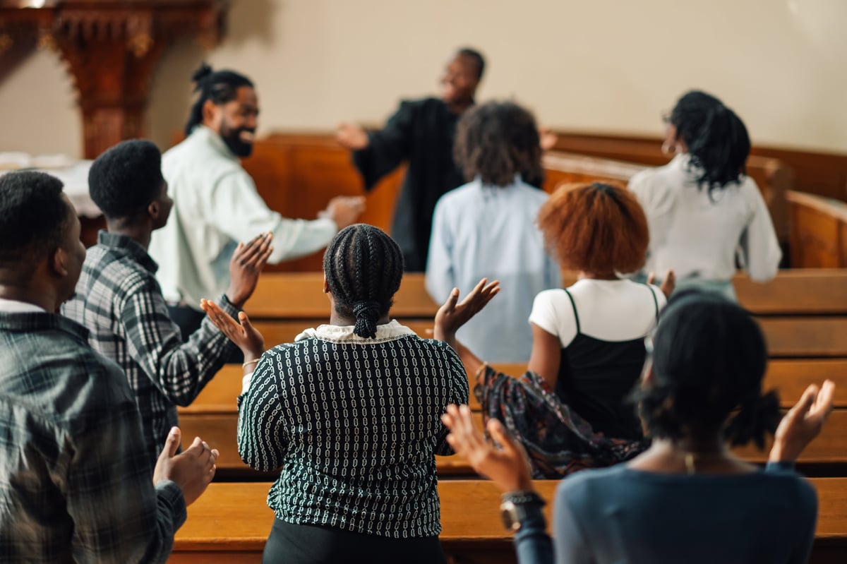 Diverse church congregation singing and raising hands in worship together