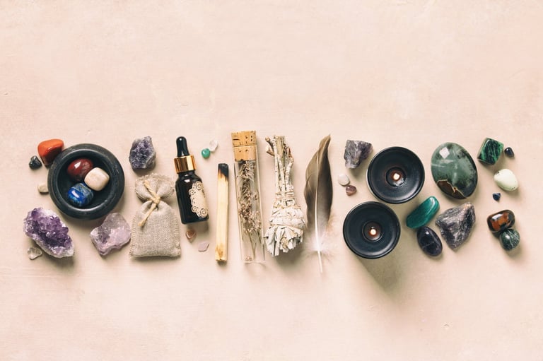 Amethyst crystals, white candle, rose quartz, and sage on soft beige background