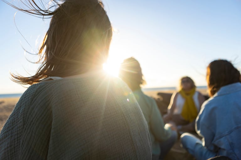 Group meditation during a healing retreat at sunset in nature
