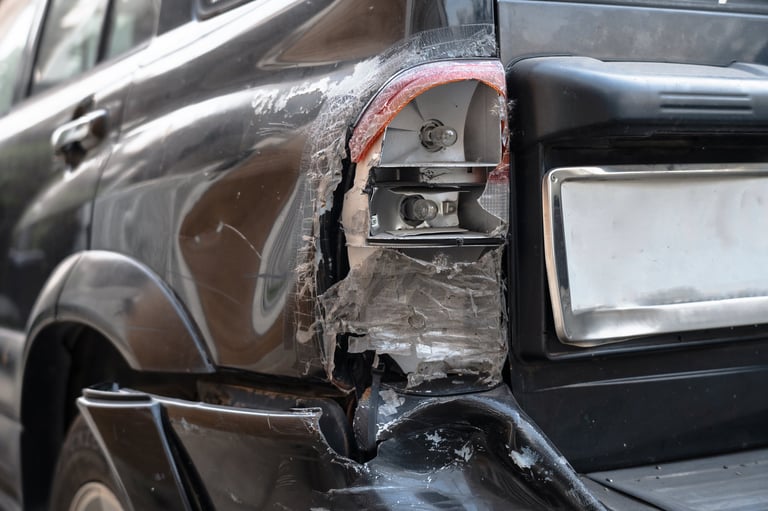 Vehicle with significant rear-end damage including broken taillight and bumper