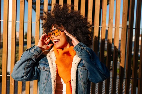 Stylish young woman with afro hair wearing orange scarf