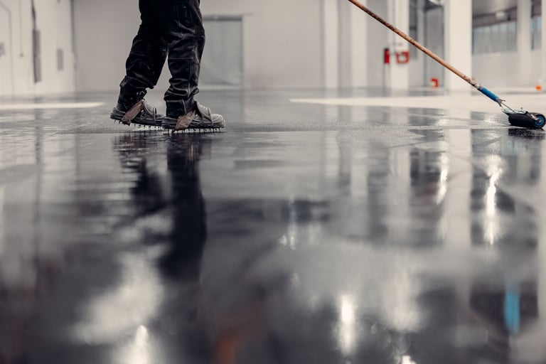 Worker applying epoxy in commercial facility