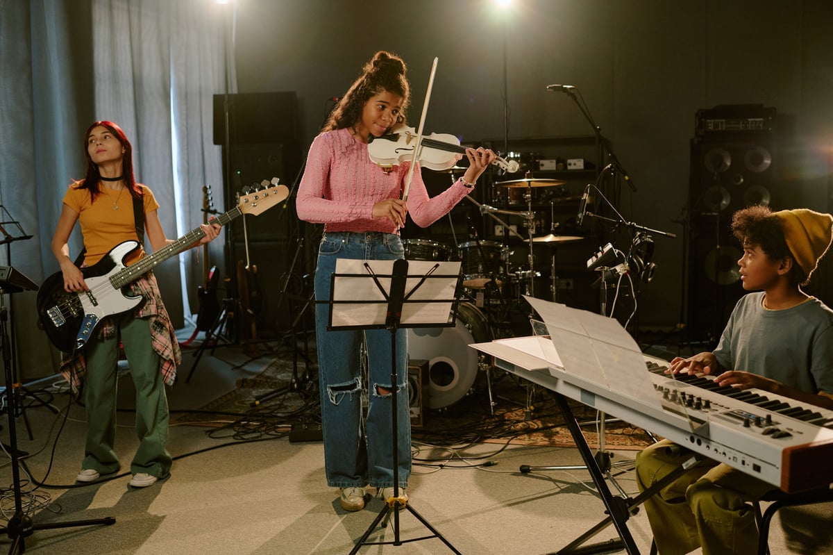 Biracial teenagers having a band rehearsal in a professional studio