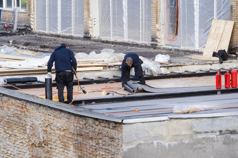 Trabajadores instalando membrana impermeabilizante en azotea