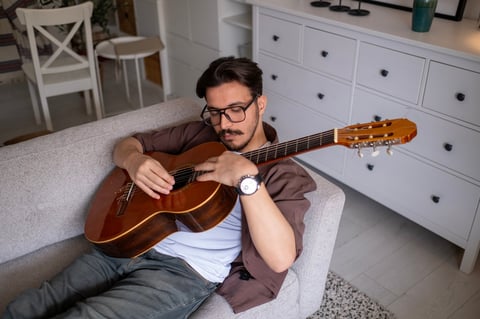 Jovem tocando violão acústico durante aula de música