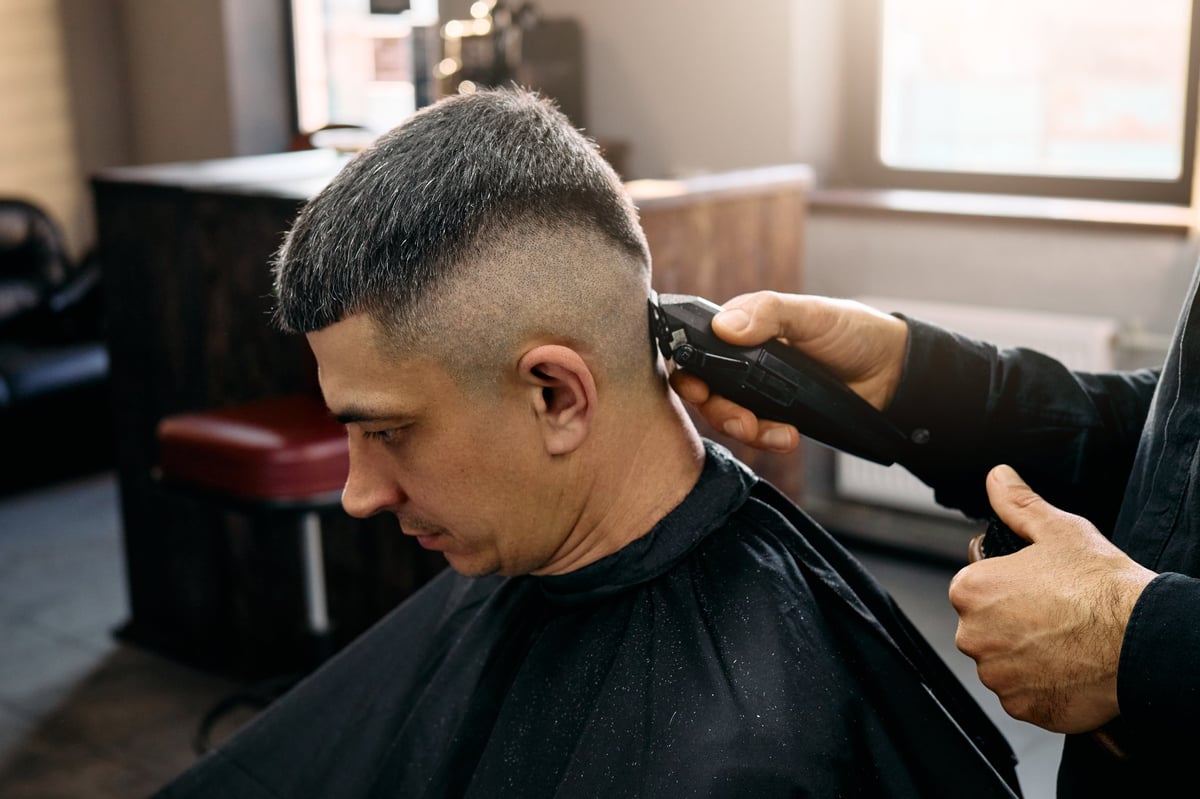 Barber using clippers to create a fade style