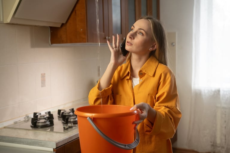 Worried homeowner dealing with water leak in kitchen