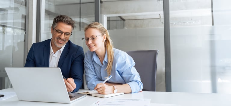 Senior mentor consulting with colleague in modern office