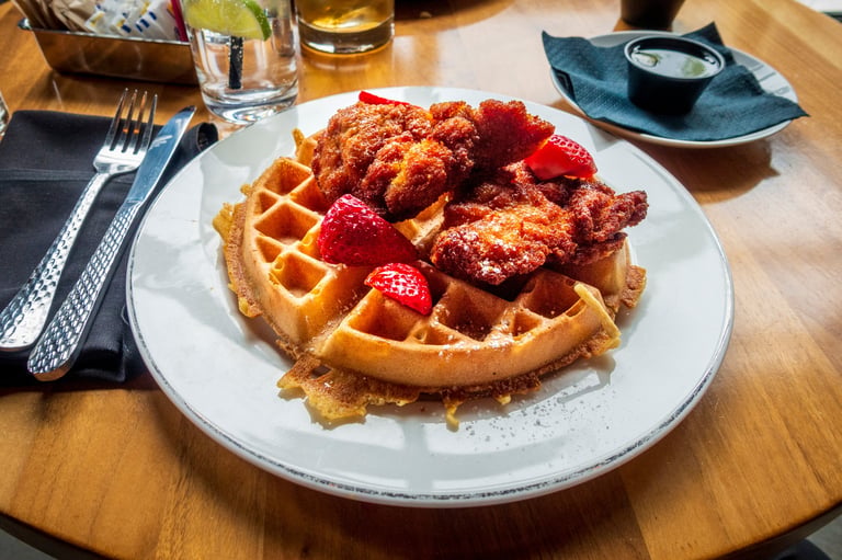 Golden, crispy fried chicken piled on a fluffy waffle with strawberries