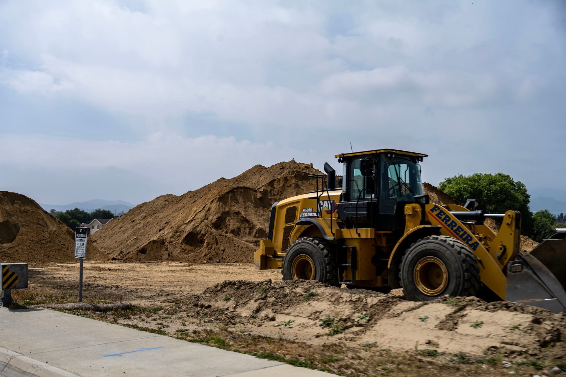 A front loader tractor working a large pile of dirt, the kind of equipment refinancing can release capital from