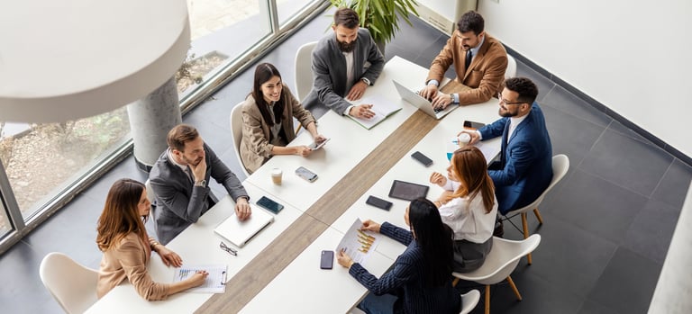 Leadership team sitting at a boardroom table during a meeting