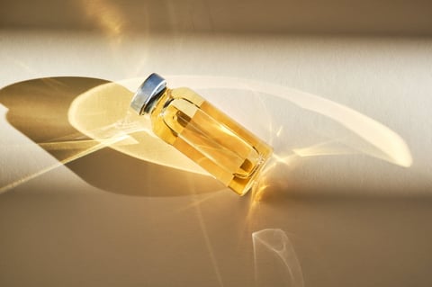 Injection vial in sunlight on beige background