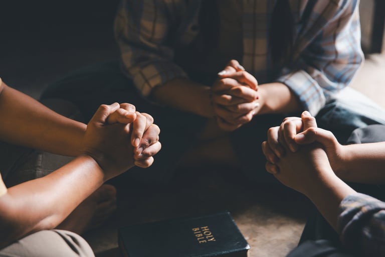 Close up group christians hands pray to God with spiritual faith on holy bible in catholic church