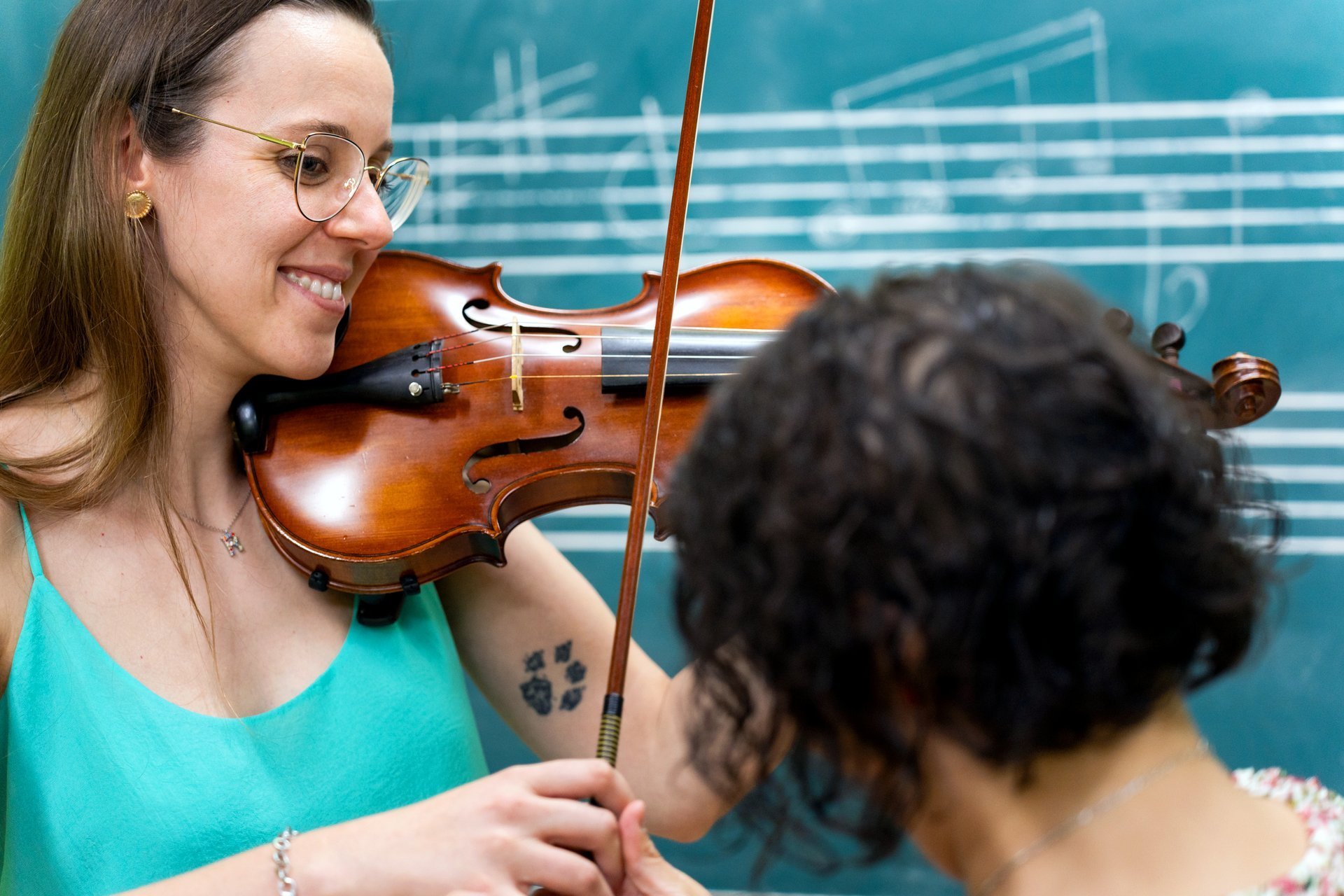 Professor de música ensinando violino para aluna