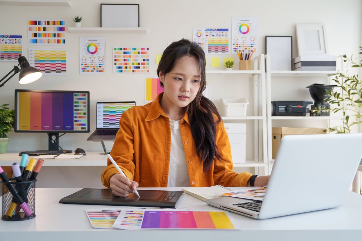 A creative small business owner working on branding materials at a design workspace, reflecting the hands-on creative process for local businesses