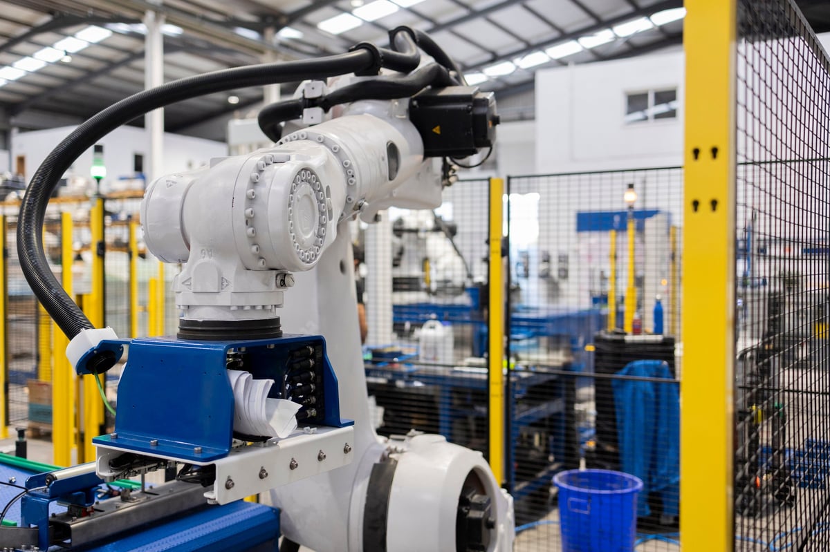 Modern robotic arm picking up material on an assembly line inside a contemporary factory, showcasing automation and advanced manufacturing processes