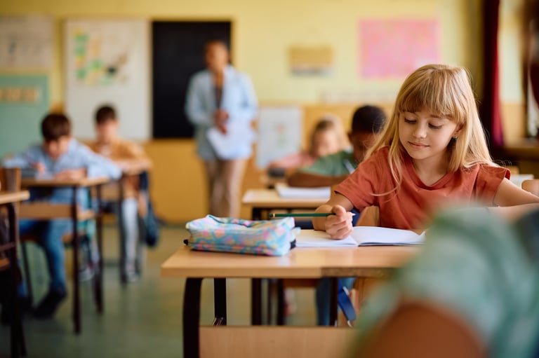 A young student focused on a classroom lesson at Lighthouse