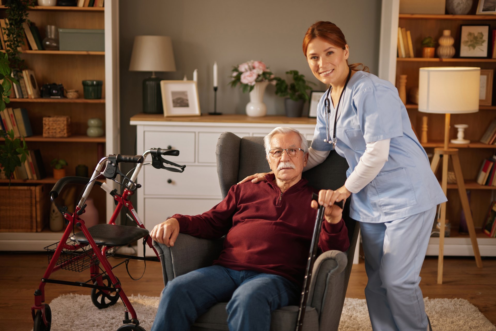 Nurse helping elderly man walk at home