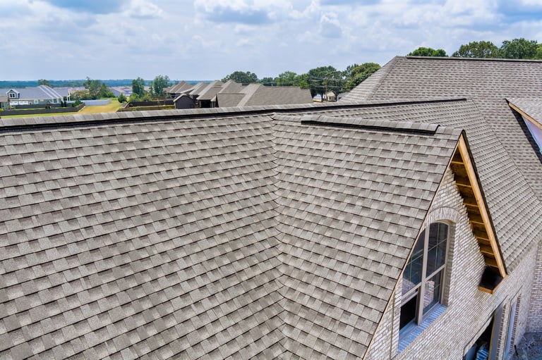New roofing on homes surrounded by lush greenery in suburban landscape