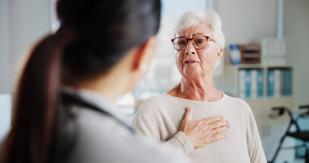 Cardiologist performing a cardiac checkup on an older woman patient in a clinic
