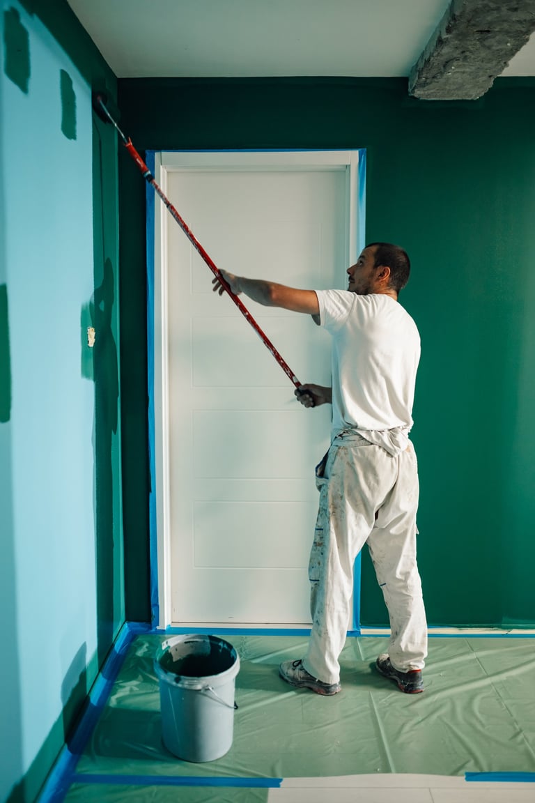 Pintor profesional aplicando pintura en pared interior