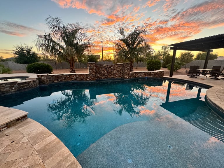 Alberca de complejo residencial con palmeras y pergola al atardecer