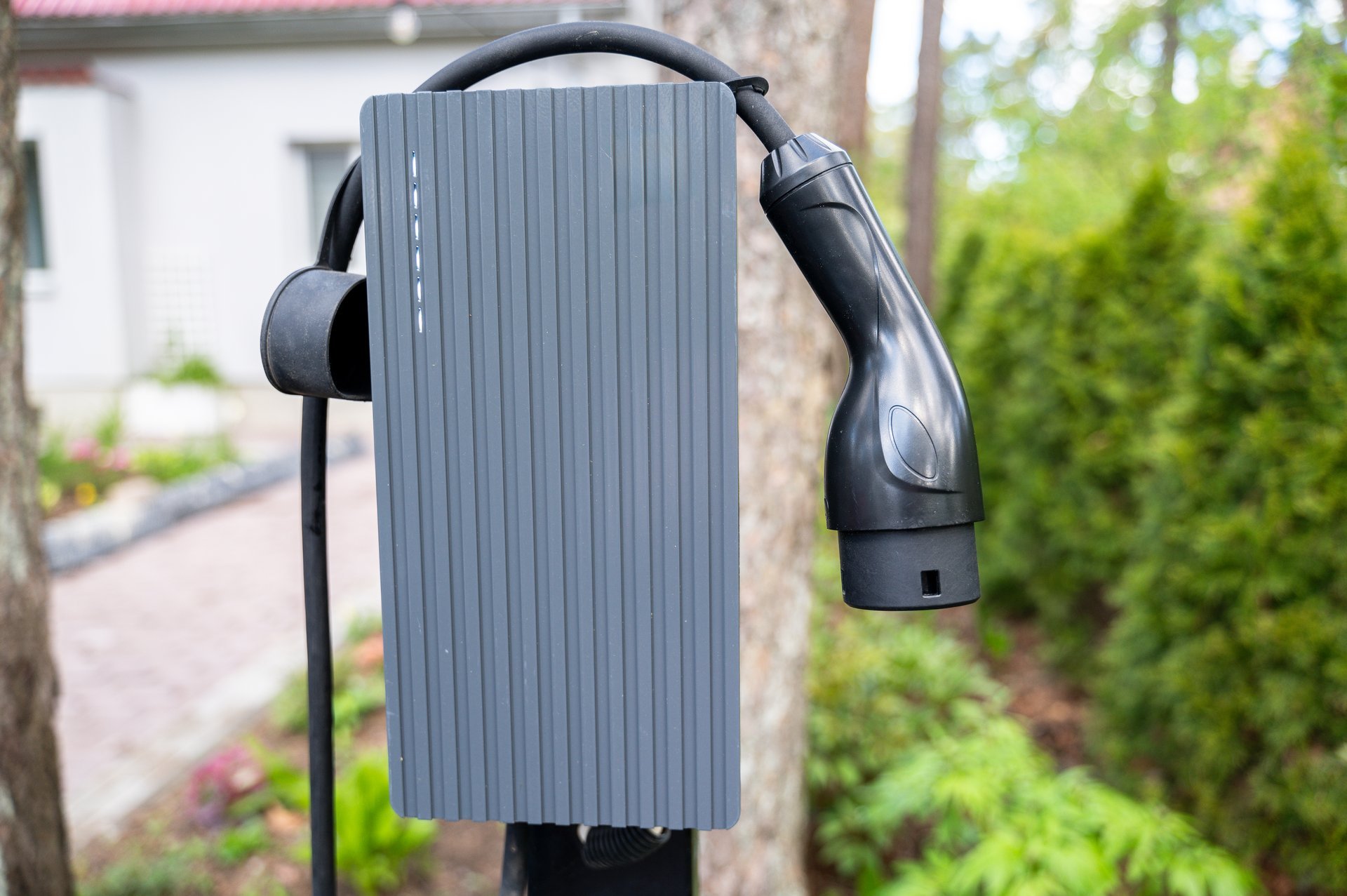 Close-up view of electric vehicle charger mounted outdoors in home driveway — CN Electrical EV charger installation services in Chilliwack, BC