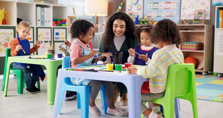 Teacher with children painting in a kindergarten classroom, early childhood education training