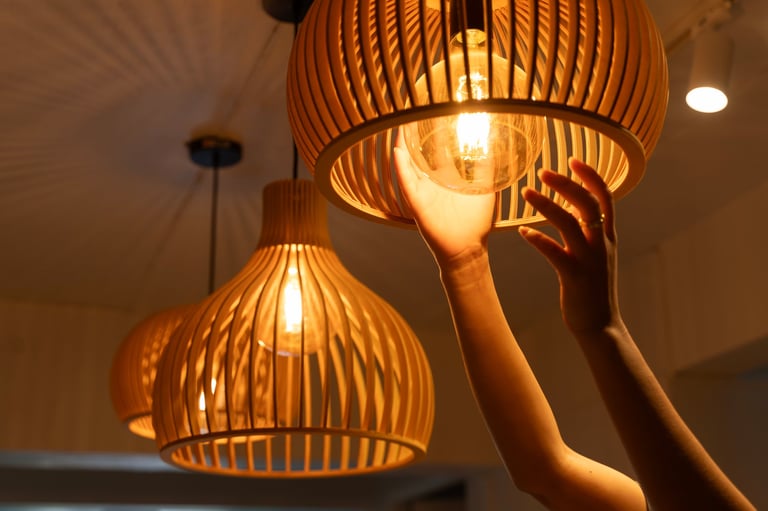 Warm glowing wooden pendant lamp being adjusted — circadian lighting that syncs with your body's natural rhythms