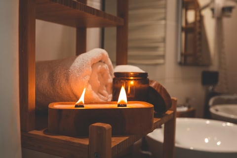 Vela encendida con mecha de madera en baño