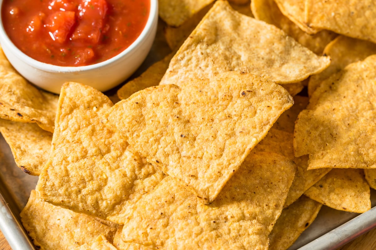 Salty homemade corn tortilla chips with two kinds of salsa