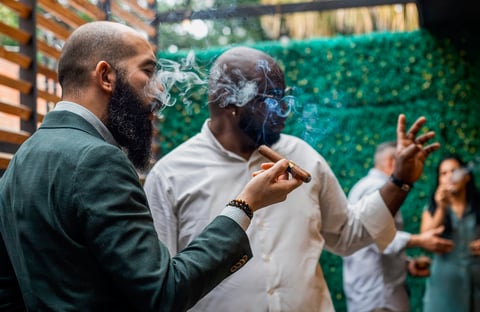 Two businessmen enjoying cigars and conversation in a sophisticated cigar lounge
