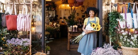 Contabilidad para pequeños comercios en Cancún — dueña de negocio local sonriendo en la entrada de su tienda