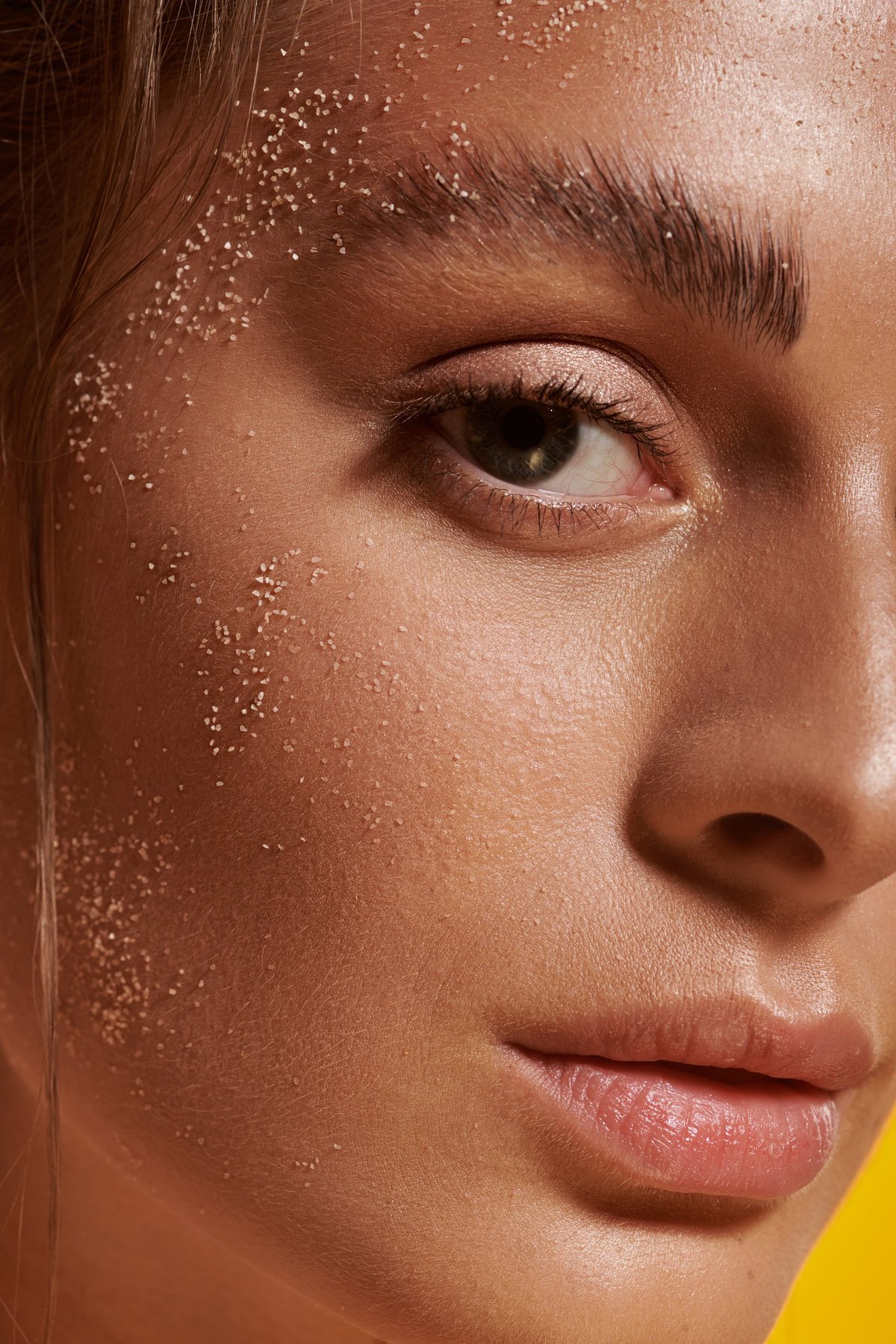 Beautiful woman showcasing confidence with sand on face