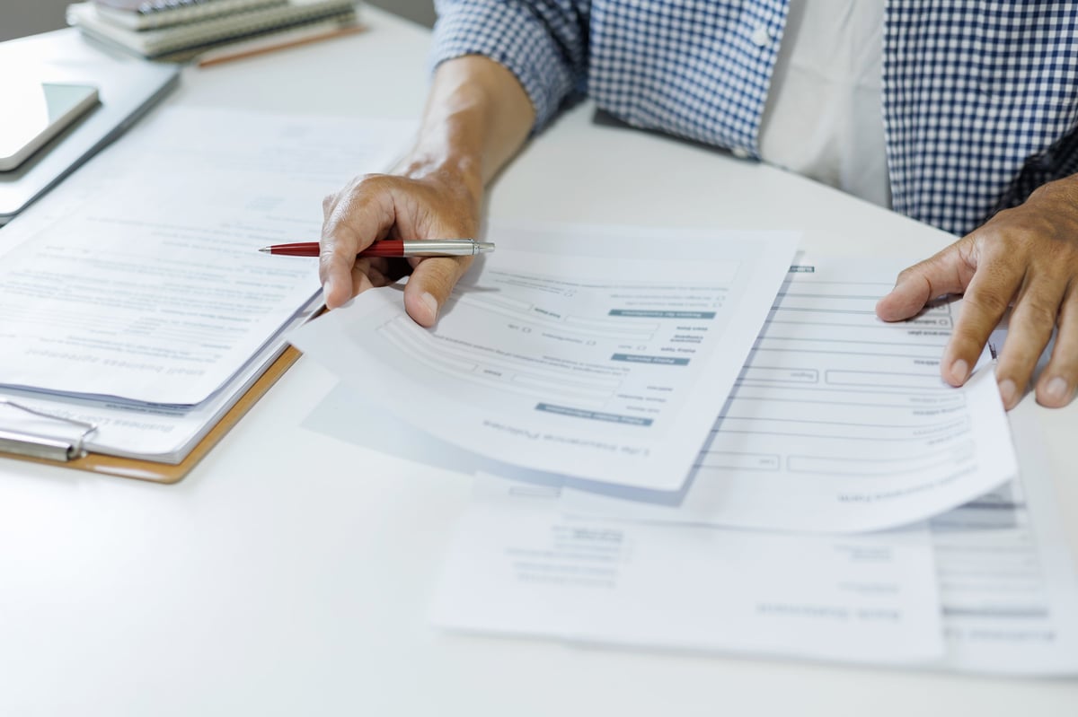 Business owner and Taycan Advisors reviewing financing options and capital documents