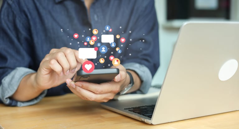 Hand holding smartphone with social media icons