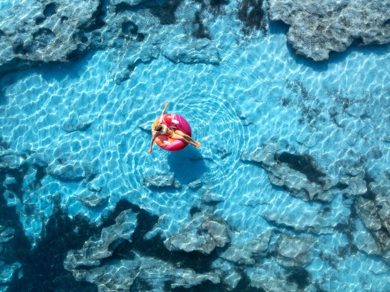 Aerial view of woman relaxing in turquoise sea