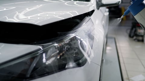 Close-up of protective film application on a headlight