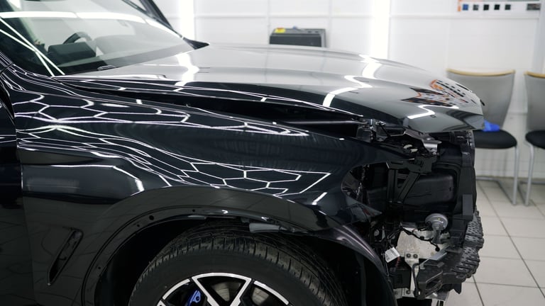 Collision repair — damaged car being restored by skilled mechanics