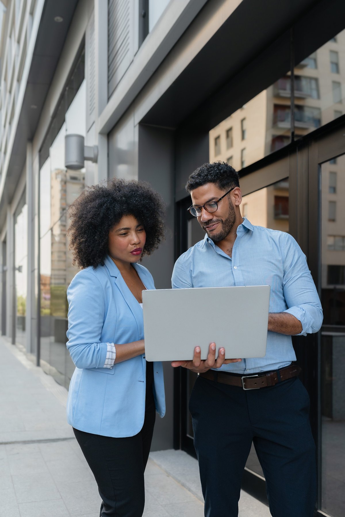 Two diverse professionals reviewing housing partnership details together outside