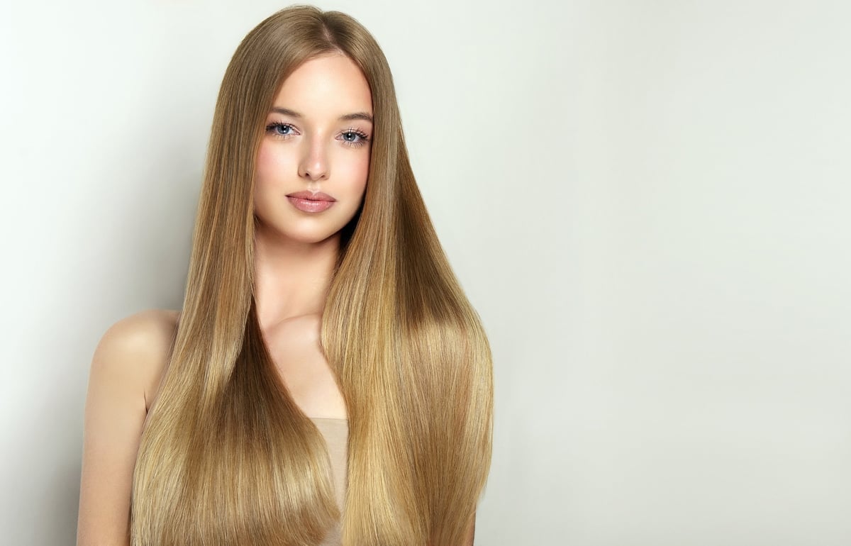 Woman with beautiful straight hair touching her locks