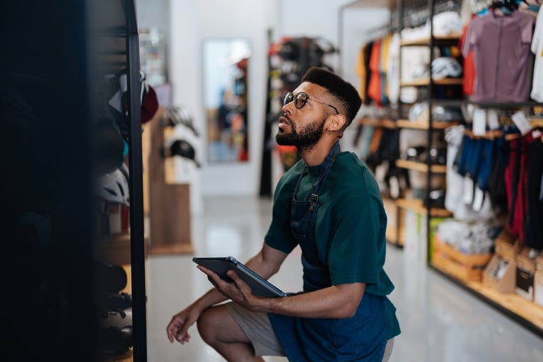 Shop owner checking inventory and orders on a tablet in a modern retail space
