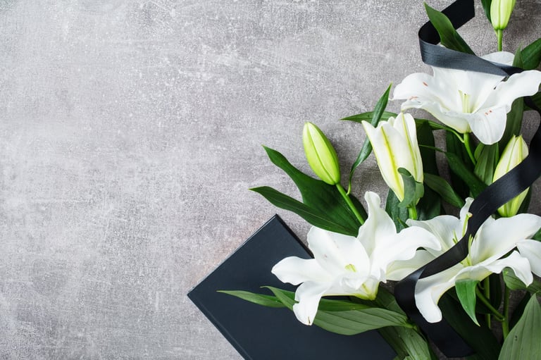 White lilies with black ribbon in remembrance